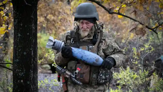 Egy ukrán katona Bahmut közelében egy gránátot visz az orosz hadseregnek szóló írásos üzenettel (AP: Efrem Lukatsky)