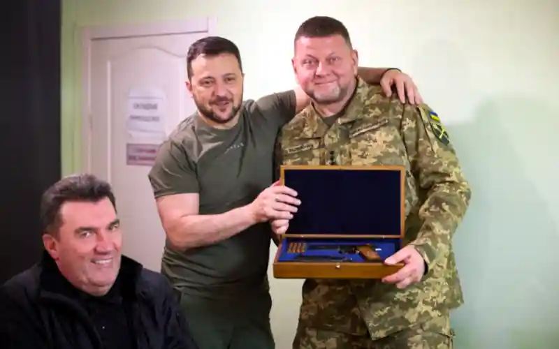 Valerij Zaluzsnyijnak, az ukrán fegyveres erők főparancsnokának a "Nevesített lőfegyver" kitüntetés átadása. A kitüntetést "Ukrajna állami szuverenitásának és területi integritásának védelmében, az ukrán állam védelmi képességének megerősítésében, a katonai szolgálat példamutató ellátásáért, becsületről és vitézségről tanúsított kiemelkedő személyes érdemeiért" ítélték oda. A képen az ukrán elnök és a főparancsnok mellett Olekszij Danyilov, az ukrán Nemzetbiztonsági és Védelmi Tanács (RNBO) titkára szerepel.